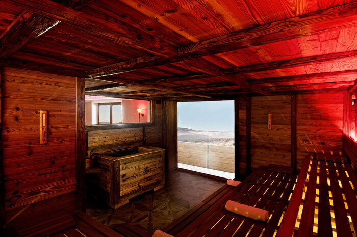 Rot beleuchtete Finnische Sauna mit viel Altholz
