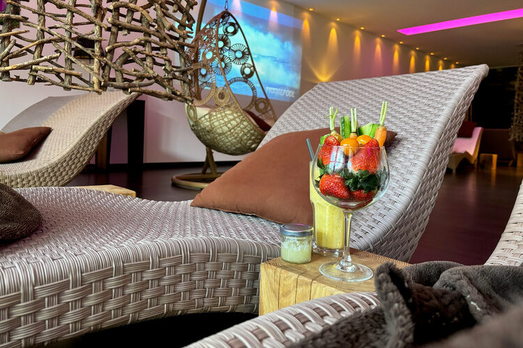 Ein großes Glas mit Früchten steht zwischen zwei Liegen