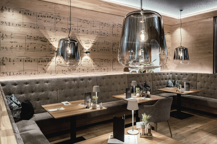 Im stilvoll eingerichteten Restaurant des Tonihofs im Bayerischen Wald schaffen sanfte Beleuchtung und bequeme Sitzplätze eine einladende Atmosphäre.