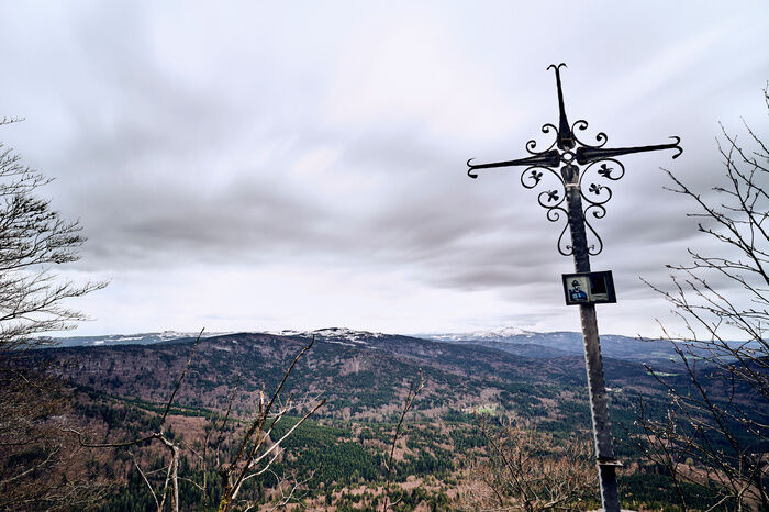Gipfelkreuz mit Blick auf die bewölkte Bayerwald-Landschaft