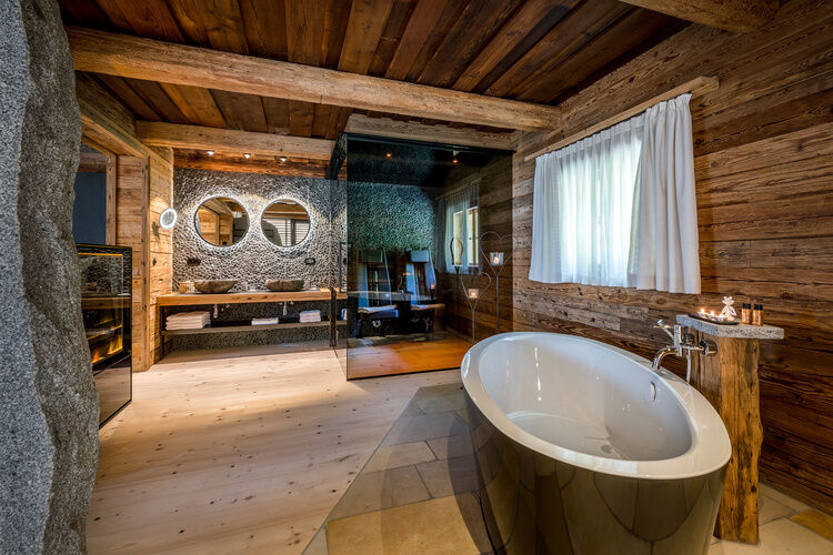 Großzügiges Badezimmer mit Doppelwaschtisch, freistehender Badewanne und Infrarotkabine im Lieblings-Chalet