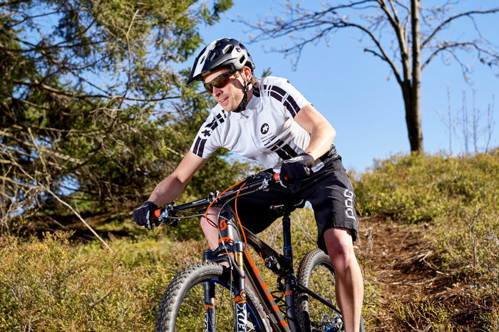 Mann beim Mountainbiken bergabwärts