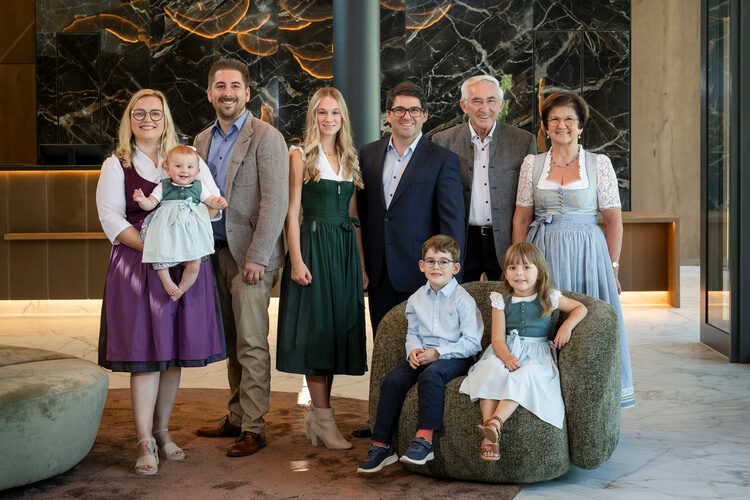 Die Gastgeberfamilie lächelt glücklich in schicker Kleidung in die Kamera.