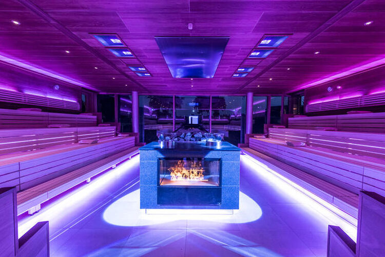 Die moderne Panorama Eventsauna ist bei Nacht mit Neonlichten angenehm beleuchtet
