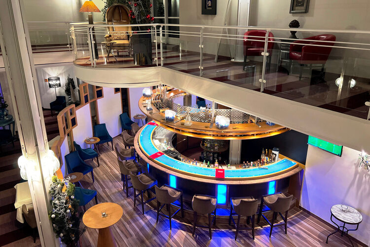 Runde Hotelbar mit blauer LED-Beleuchtung im modernen, zweistöckigen Loungebereich.