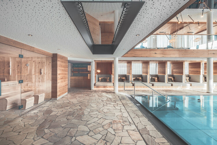 Ein einladendes Hallenbad mit großzügigem Steinboden im Tonihof.