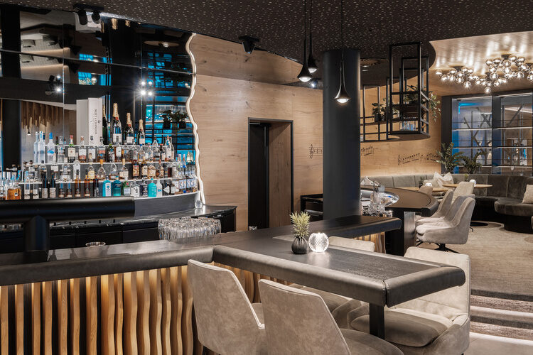 Eine moderne Bar im Tonihof mit stilvollen Stühlen und Tischen.