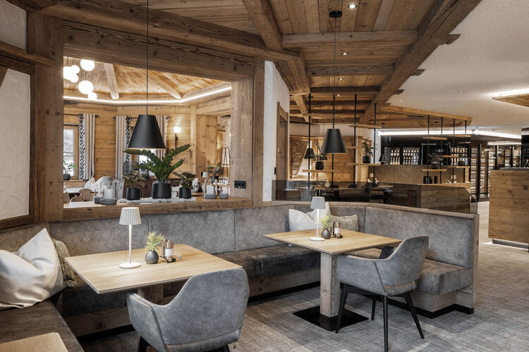 Der Speisesaal mit elegantem Design und mehreren Tischen und Stühlen im Tonihof.