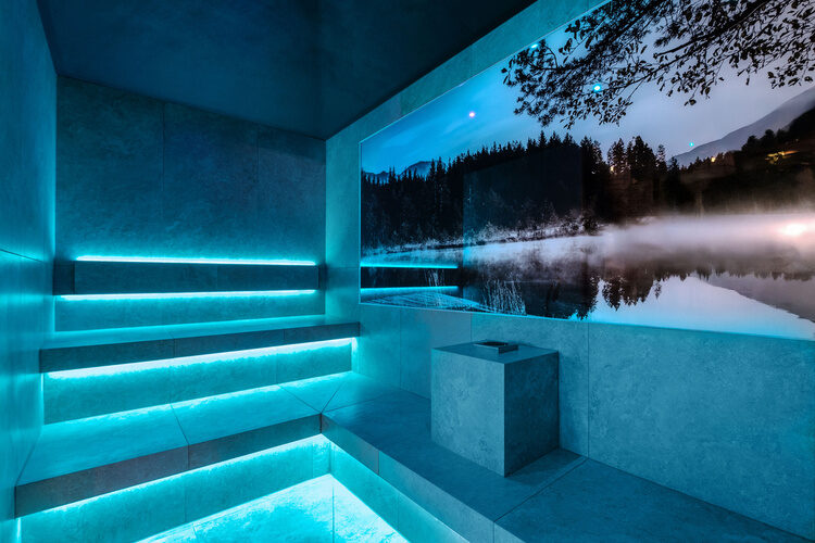 Eine Sauna im Tonihof mit blauem Licht unter einem sternenklaren Himmel.